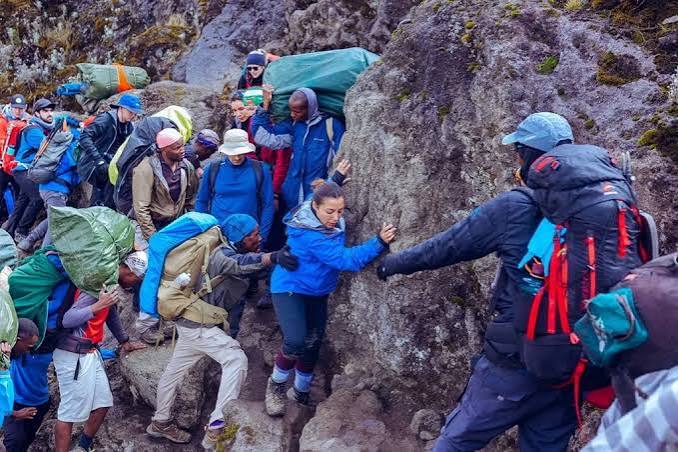 Trekkers scrambling up the Barranco Wall en route to Karanga Camp on Mount Kilimanjaro