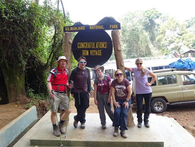 Hikers receiving summit certificates at Mweka Gate after descending Mount Kilimanjaro